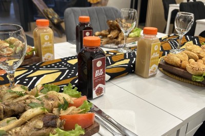 Boissons en bouteilles et assortiments de pâtisseries disposés sur une table décorée de motifs colorés.