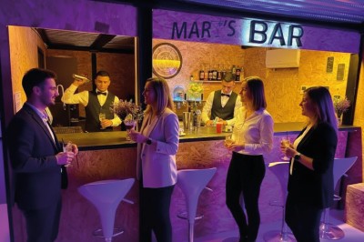 Table élégamment dressée avec verres, bougies et bouquet de fleurs séchées dans une ambiance tamisée.