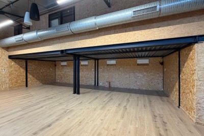 Salle de spectacle avec scène éclairée, artistes en représentation et public assis dans des fauteuils rouges.