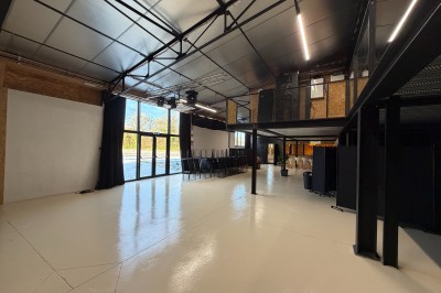 Salle de spectacle avec scène éclairée, artistes en représentation et public assis dans des fauteuils rouges.