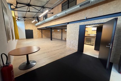 Salle de spectacle avec scène éclairée, artistes en représentation et public assis dans des fauteuils rouges.