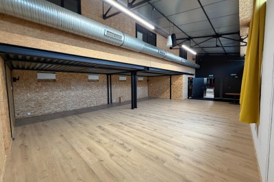 Salle de spectacle avec scène éclairée, artistes en représentation et public assis dans des fauteuils rouges.