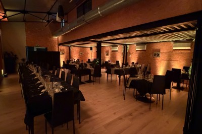 Salle de spectacle avec scène éclairée, artistes en représentation et public assis dans des fauteuils rouges.