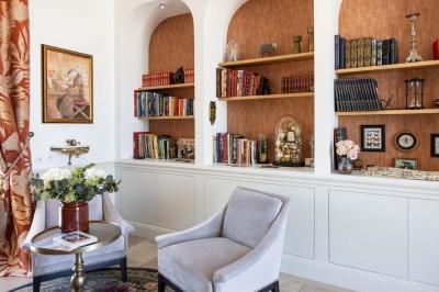 Un âne et un bélier se touchent le museau dans un pré verdoyant sous un ciel dégagé.