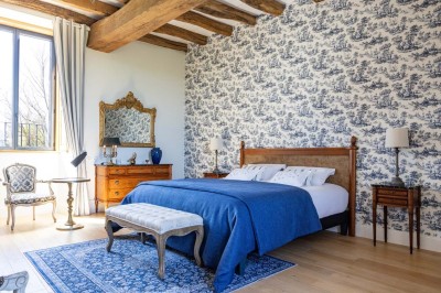 Un âne et un bélier se touchent le museau dans un pré verdoyant sous un ciel dégagé.