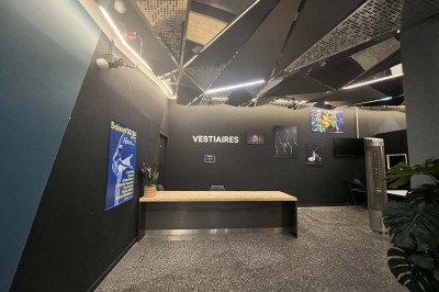 Scène éclairée avec instruments de musique, tabourets et écran affichant un logo ’ESB’ sur un fond de briques.