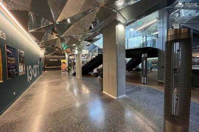 Scène éclairée avec instruments de musique, tabourets et écran affichant un logo ’ESB’ sur un fond de briques.