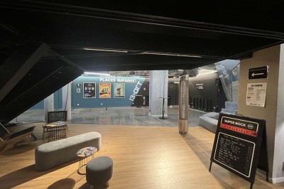 Scène éclairée avec instruments de musique, tabourets et écran affichant un logo ’ESB’ sur un fond de briques.