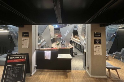 Scène éclairée avec instruments de musique, tabourets et écran affichant un logo ’ESB’ sur un fond de briques.