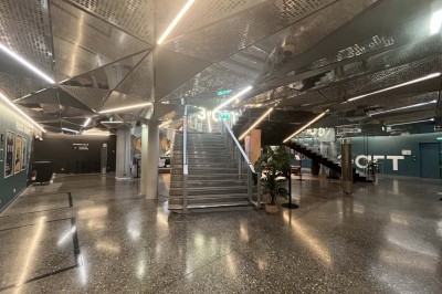 Scène éclairée avec instruments de musique, tabourets et écran affichant un logo ’ESB’ sur un fond de briques.