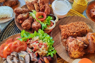Pilons de poulet rôtis disposés sur un lit de salade verte avec une décoration en forme de rose en tomate.