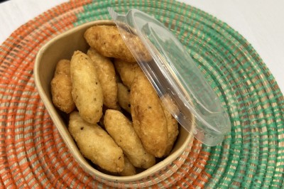 Pilons de poulet rôtis disposés sur un lit de salade verte avec une décoration en forme de rose en tomate.