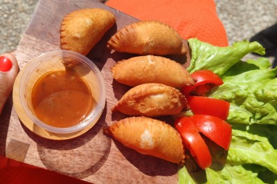 Pilons de poulet rôtis disposés sur un lit de salade verte avec une décoration en forme de rose en tomate.