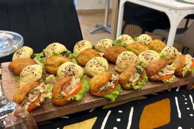 Pilons de poulet rôtis disposés sur un lit de salade verte avec une décoration en forme de rose en tomate.