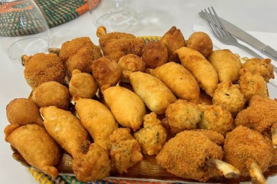 Pilons de poulet rôtis disposés sur un lit de salade verte avec une décoration en forme de rose en tomate.