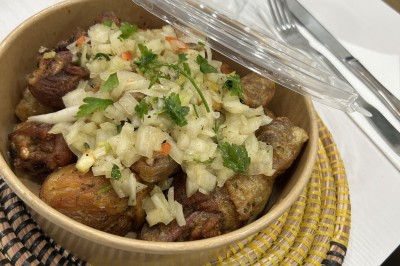 Pilons de poulet rôtis disposés sur un lit de salade verte avec une décoration en forme de rose en tomate.