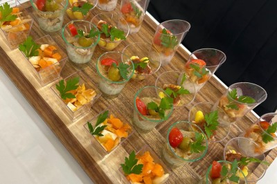 Pilons de poulet rôtis disposés sur un lit de salade verte avec une décoration en forme de rose en tomate.