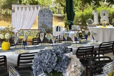 Terrasse animée d'un restaurant en soirée, avec des guirlandes lumineuses et des convives attablés sous un arbre.