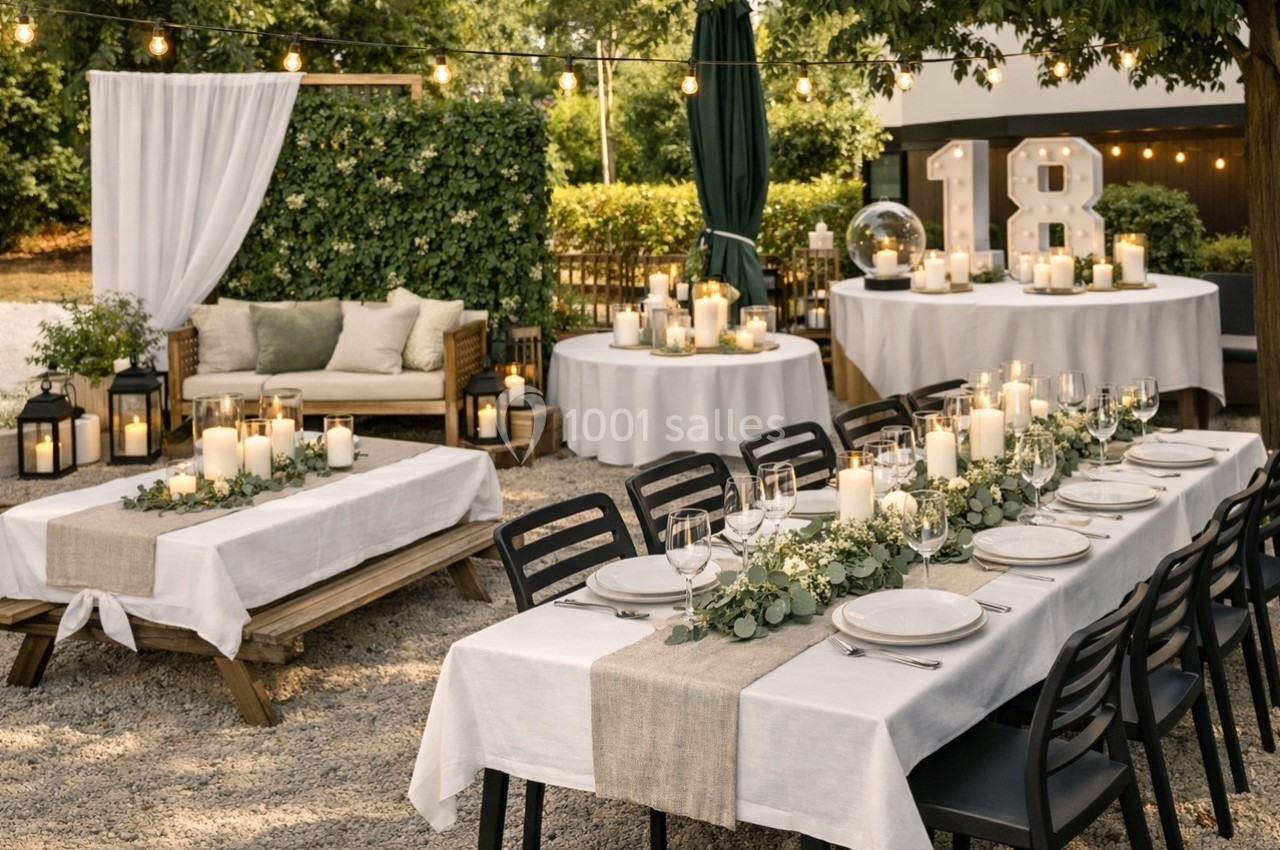 Tables décorées avec nappes blanches, bougies et feuillage, disposées en extérieur pour une fête, avec un panneau ’18’.