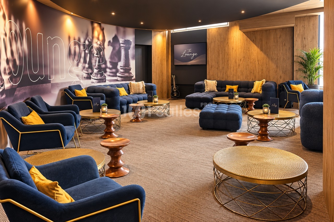 Lounge aux murs bois - fauteuils bleu marine et noir avec passepoil doré, tables basses rondes en bois, éclairage tamisé.