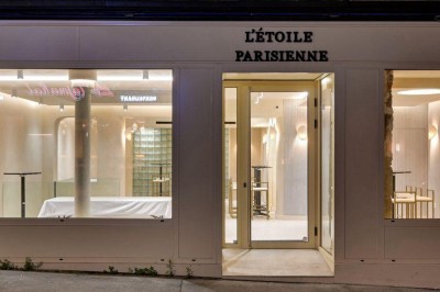 Deux lavabos en pierre avec un vase de fleurs pastel au centre, devant un miroir à double courbure.