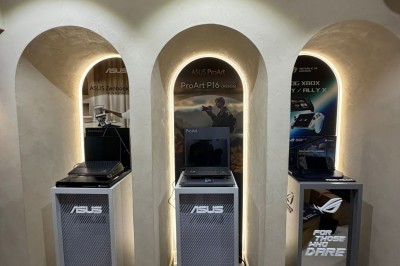 Façade d'une boutique avec vitrines éclairées, affichant des produits ASUS et un panneau ’ASUS Partner Day’.