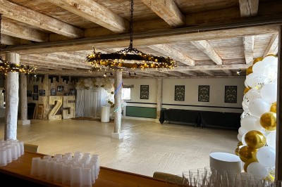 Salle de réception avec plafond en bois, décorations lumineuses et chiffre ’25’ illuminé en arrière-plan.