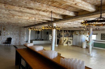 Salle de réception avec plafond en bois, décorations lumineuses et chiffre ’25’ illuminé en arrière-plan.