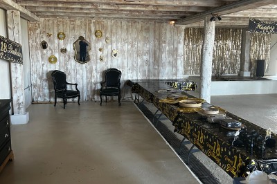 Bannière ’Happy 18th Birthday’ suspendue dans une pièce avec plafond en bois et décorations dorées scintillantes.