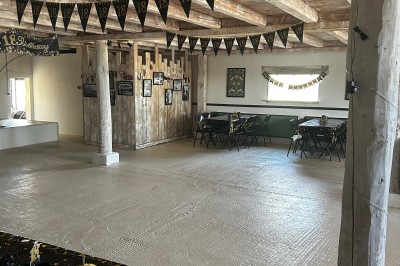 Bannière ’Happy 18th Birthday’ suspendue dans une pièce avec plafond en bois et décorations dorées scintillantes.