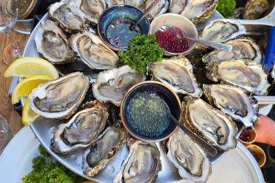 Miniature Location salle Paris 9 (Paris) - Les Blancs Becs #33 Plateau d'huîtres fraîches disposées autour de sauces, accompagné de quartiers de citron et de persil.