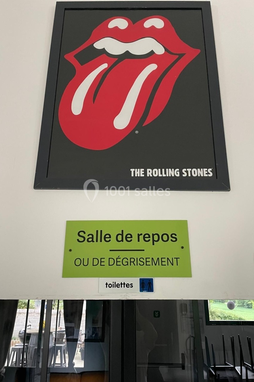 Affiche des Rolling Stones au-dessus d'un panneau indiquant ’Salle de repos ou de dégrisement’ avec un pictogramme de…