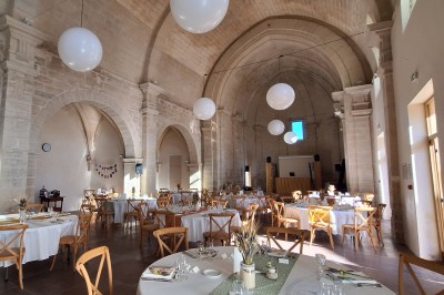 Cuisine professionnelle avec plans de travail en inox, évier, étagères et deux grandes portes de chambre froide.