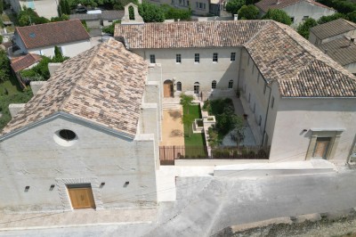 Cuisine professionnelle avec plans de travail en inox, évier, étagères et deux grandes portes de chambre froide.