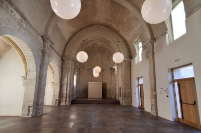 Cuisine professionnelle avec plans de travail en inox, évier, étagères et deux grandes portes de chambre froide.