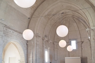 Cuisine professionnelle avec plans de travail en inox, évier, étagères et deux grandes portes de chambre froide.