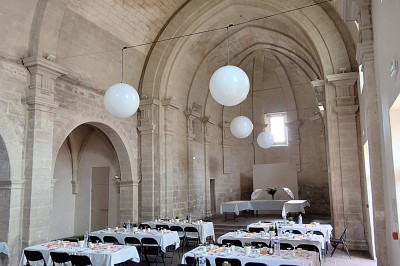 Cuisine professionnelle avec plans de travail en inox, évier, étagères et deux grandes portes de chambre froide.