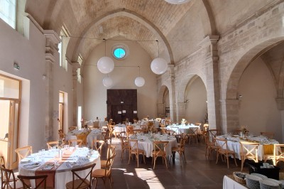 Cuisine professionnelle avec plans de travail en inox, évier, étagères et deux grandes portes de chambre froide.