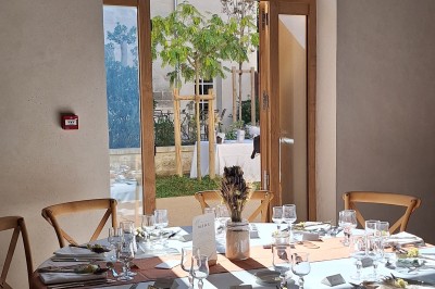 Cuisine professionnelle avec plans de travail en inox, évier, étagères et deux grandes portes de chambre froide.