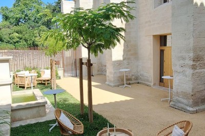 Cuisine professionnelle avec plans de travail en inox, évier, étagères et deux grandes portes de chambre froide.