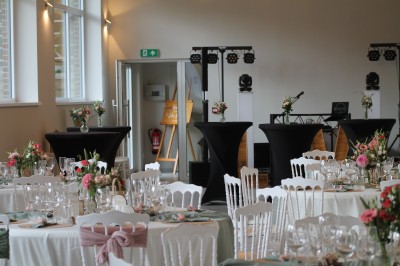 Miniature Location salle Comines-Warneton (Hainaut) - Salle de l'Arrière Boutique #3 Salle décorée pour un événement avec des chaises blanches ornées de nœuds en tissu rose et vert autour d'une table dressée.