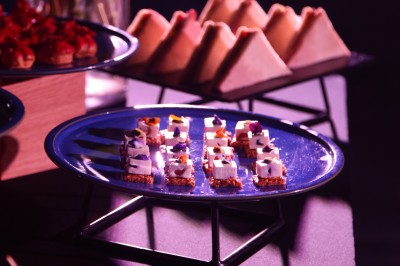 Tunnel d'aquarium avec un grand bassin à droite, éclairages colorés et écran lumineux sur le mur gauche.
