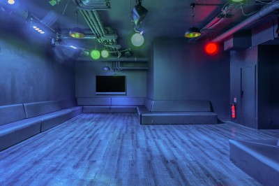 Tunnel d'aquarium avec un grand bassin à droite, éclairages colorés et écran lumineux sur le mur gauche.