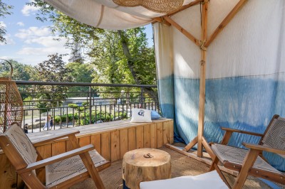 Tunnel d'aquarium avec un grand bassin à droite, éclairages colorés et écran lumineux sur le mur gauche.