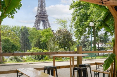 Tunnel d'aquarium avec un grand bassin à droite, éclairages colorés et écran lumineux sur le mur gauche.
