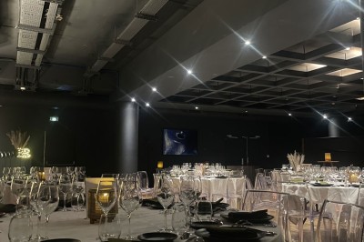 Tunnel d'aquarium avec un grand bassin à droite, éclairages colorés et écran lumineux sur le mur gauche.