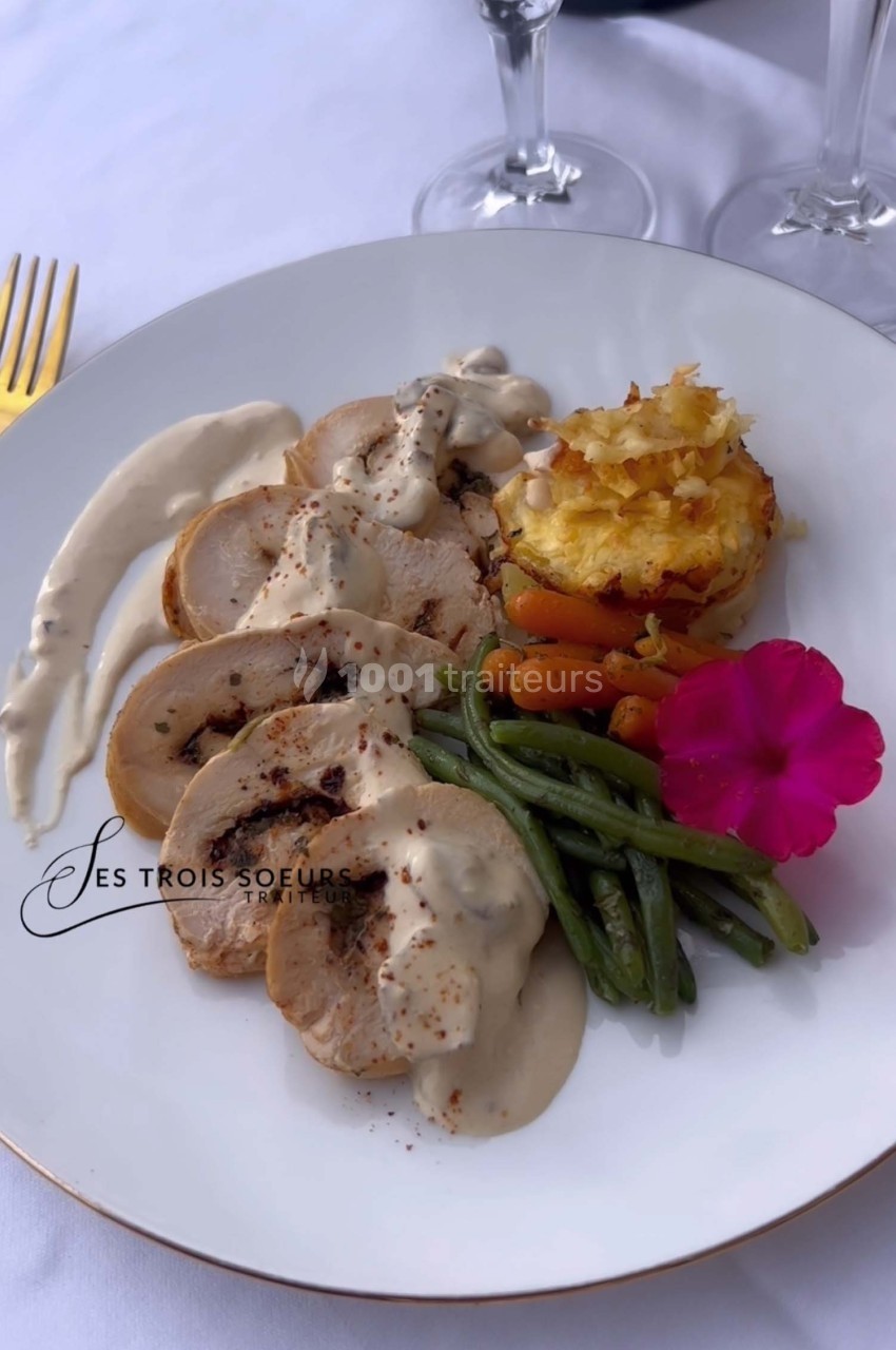 Assiette composée de tranches de volaille sauce crème, haricots verts, carottes, gratin et fleur décorative.