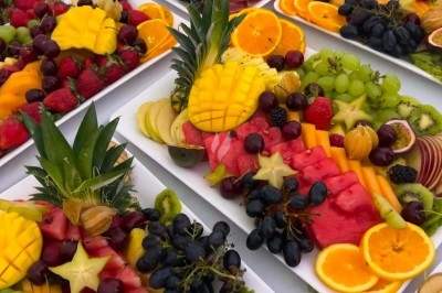 Table de réception élégamment dressée avec chandeliers, fleurs pourpres et vaisselle raffinée dans une salle lumineuse.