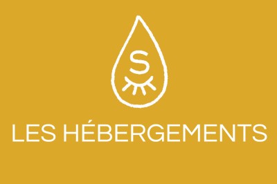 Façade en pierre éclairée d'une bâtisse ancienne avec une enseigne lumineuse, vue de nuit.