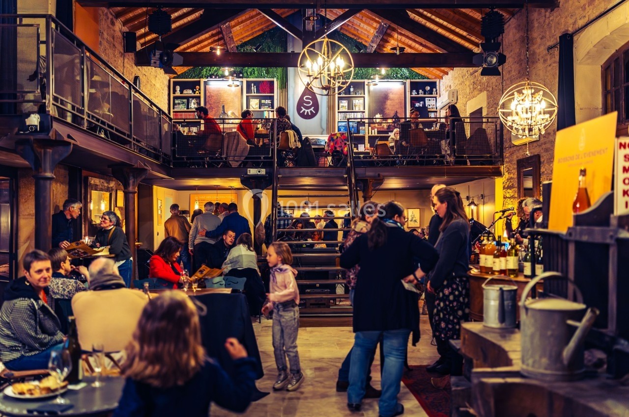 Intérieur d'un café animé avec des clients discutant, lisant et profitant d'une ambiance chaleureuse et conviviale.